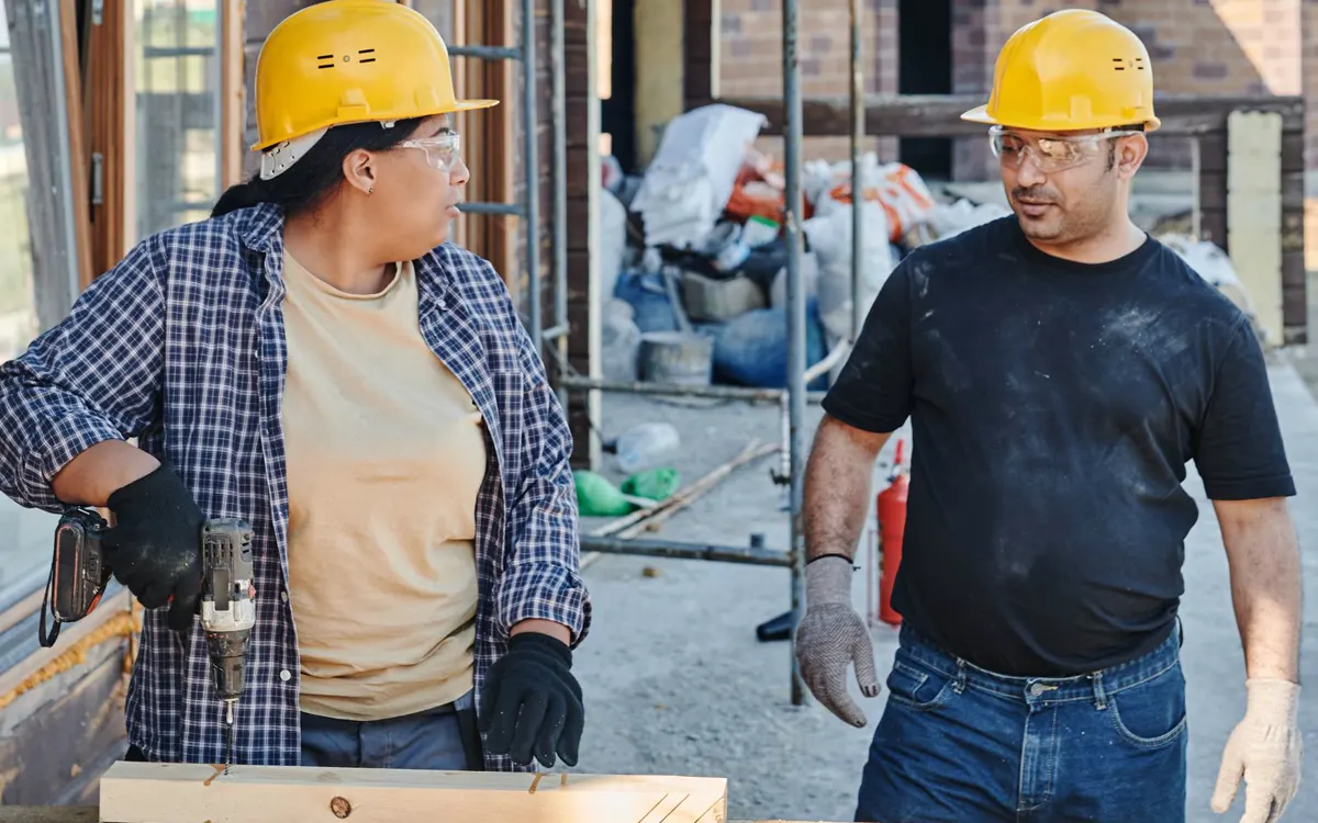 Construction workers coordinating on a building site, the kind of team PoC radios keep connected across a whole project