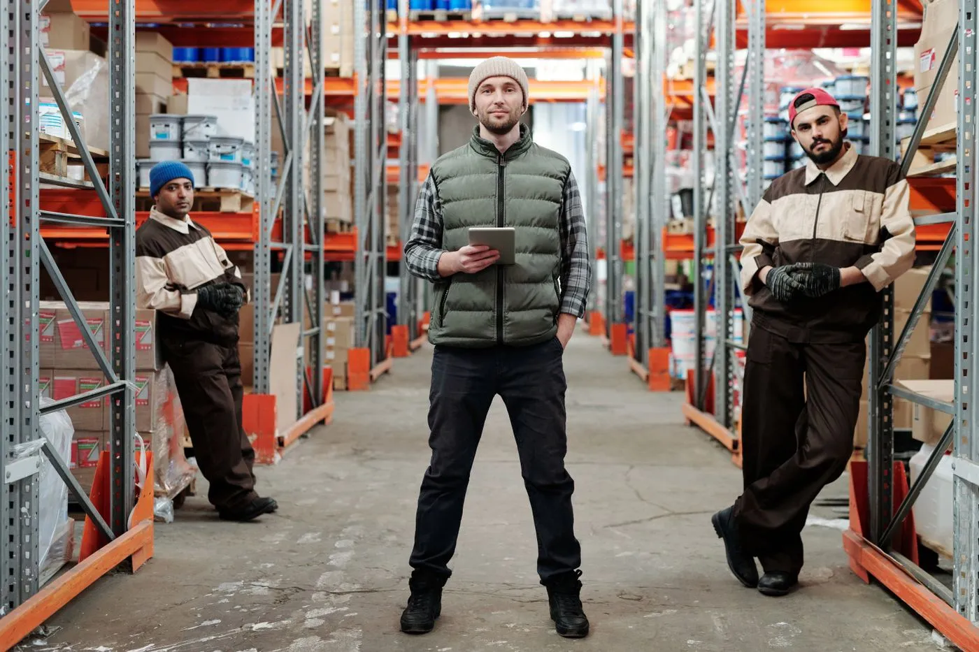 Warehouse team in a pallet racking aisle, where two way radios for warehouses keep staff connected across the site